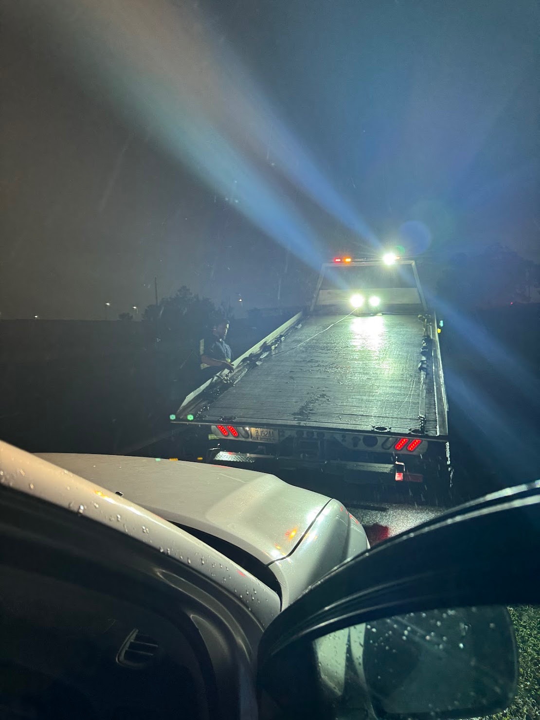 Driver's view following a Hookline flatbed on a rainy Orlando night